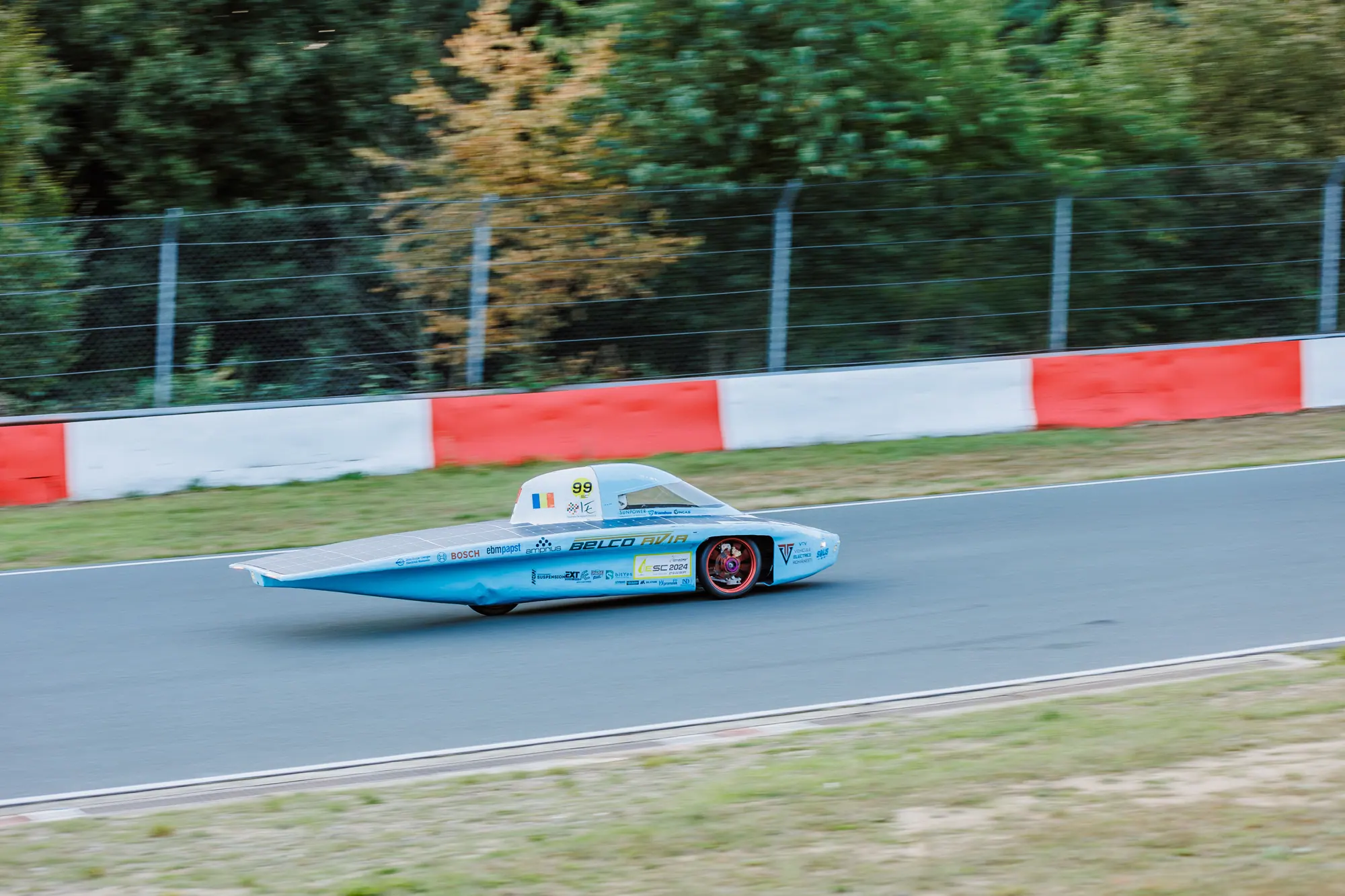 EV4 pe circuit, cu parapetul roșu-alb în spate.
