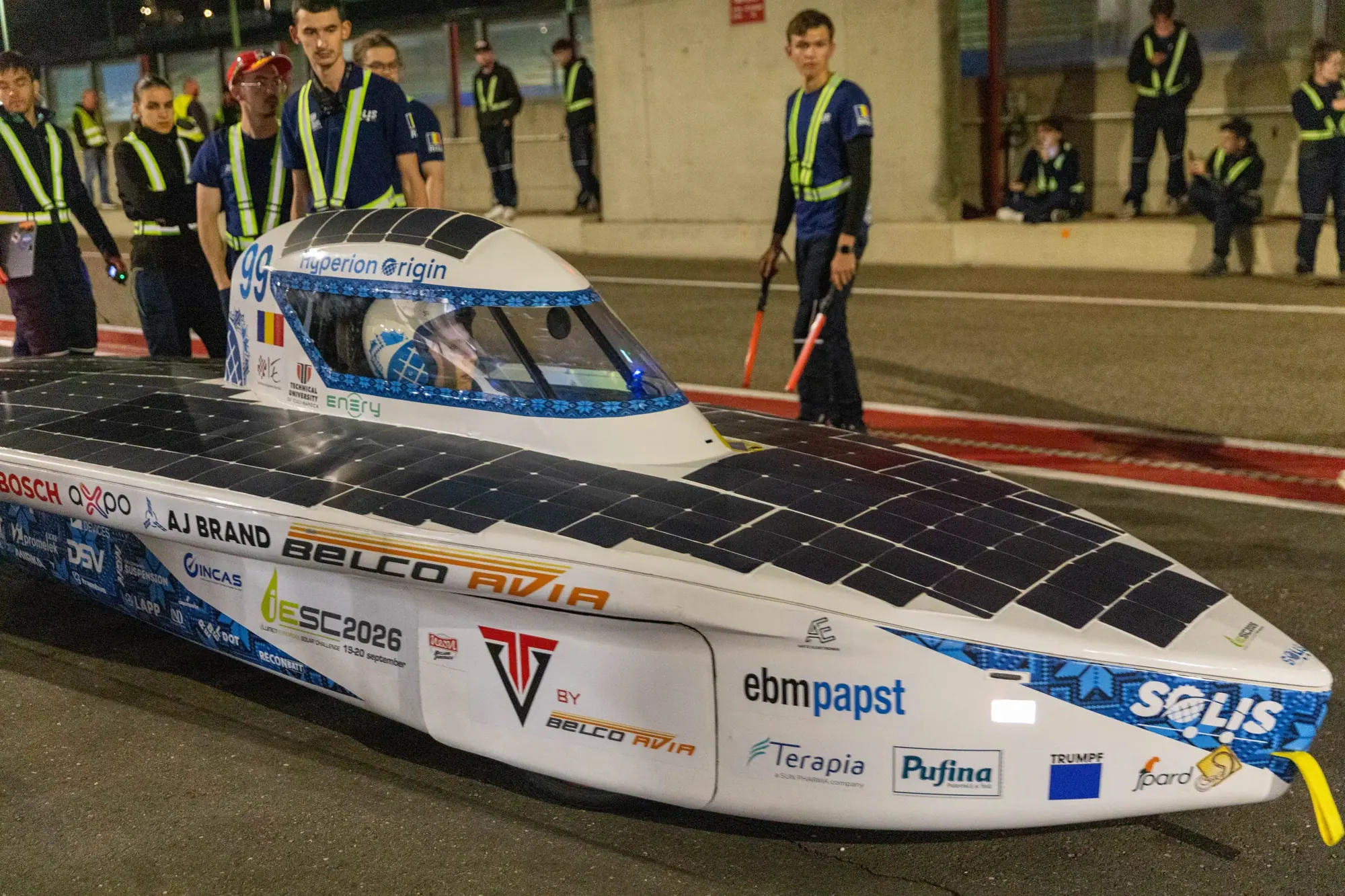 Hyperion Origin noaptea, pe pit lane la Zolder, cu caroseria acoperită de logo-urile partenerilor.